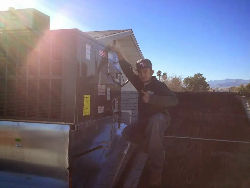 HVAC technician performing AC Tune-Up on a rooftop unit in Runnemede